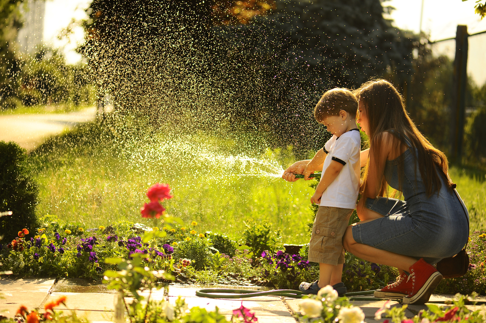 woman and child watering the lawn