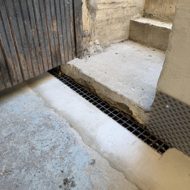 Completed drainage grate at a basement bulkhead entrance