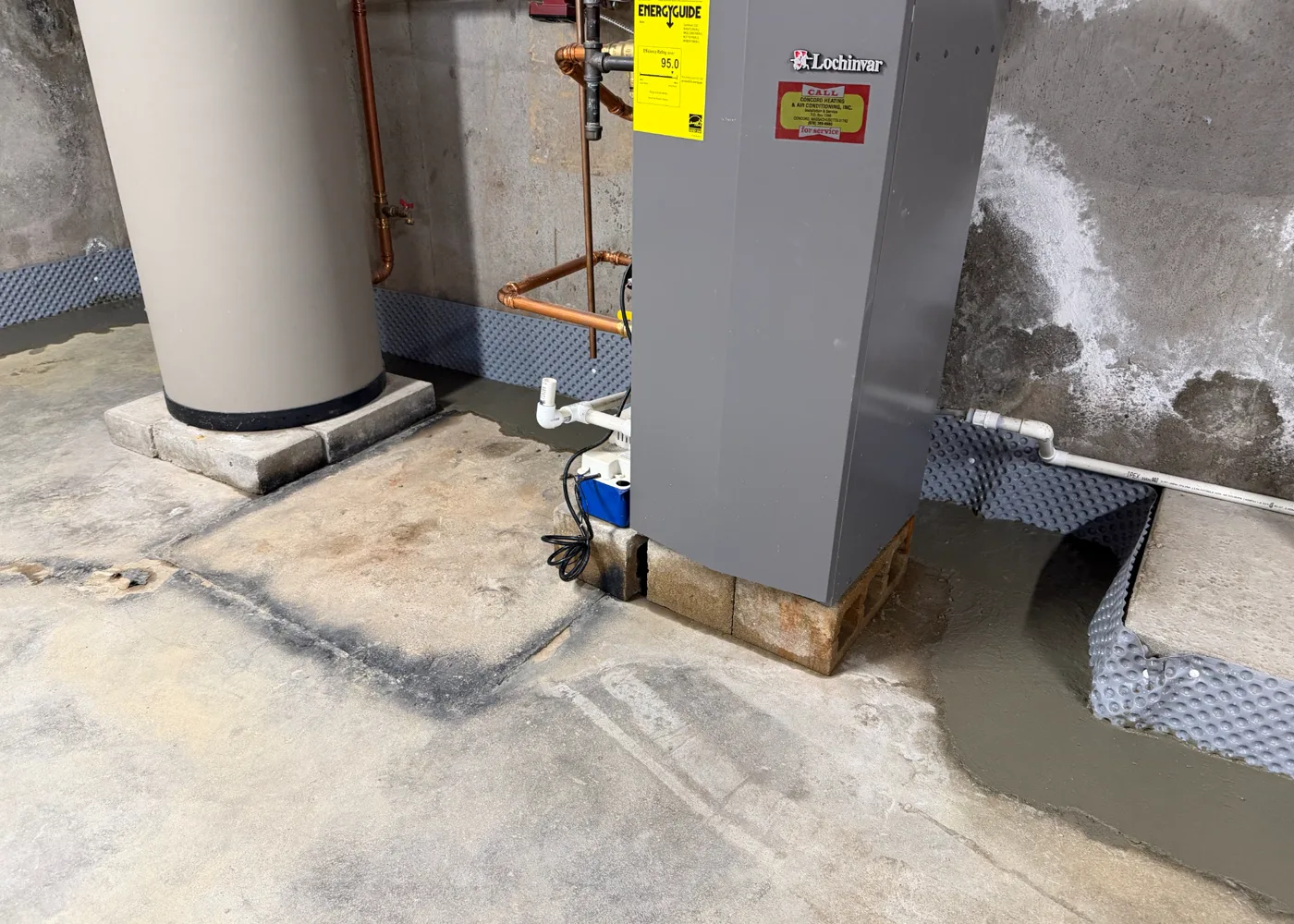 Finished B-Dry interior drainage system routed around a water heater and furnace