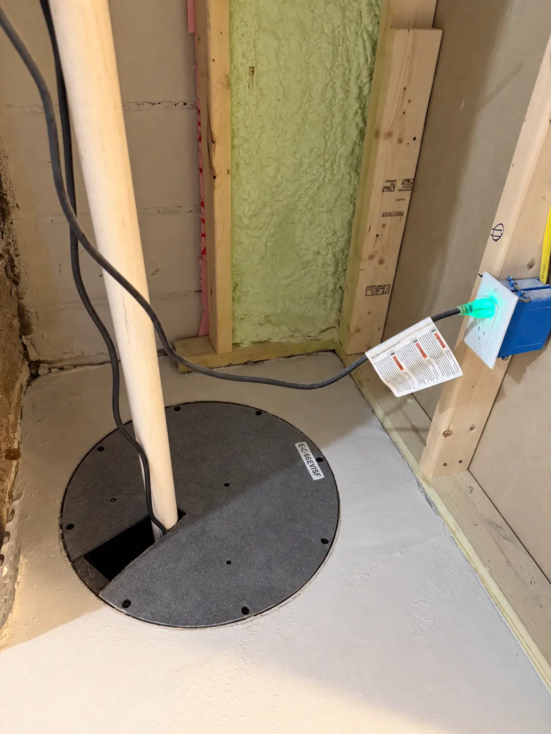 Finished B‑Dry sump well with clean cover and discharge piping