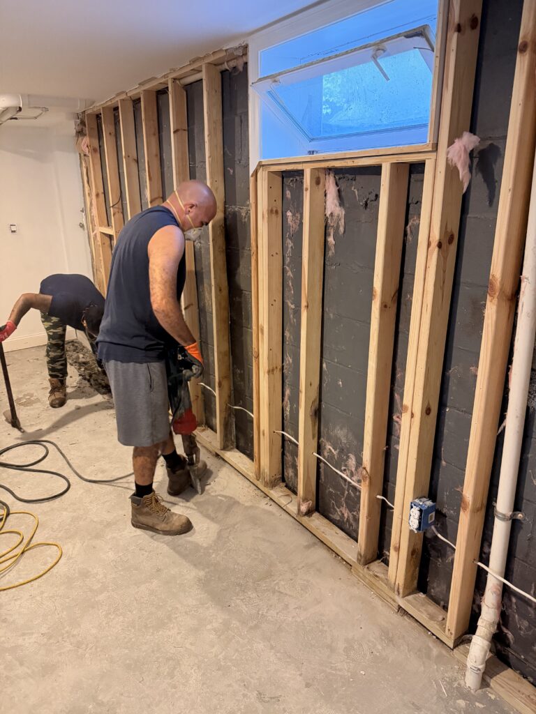 B‑Dry crew member opening the basement floor for an interior drainage system