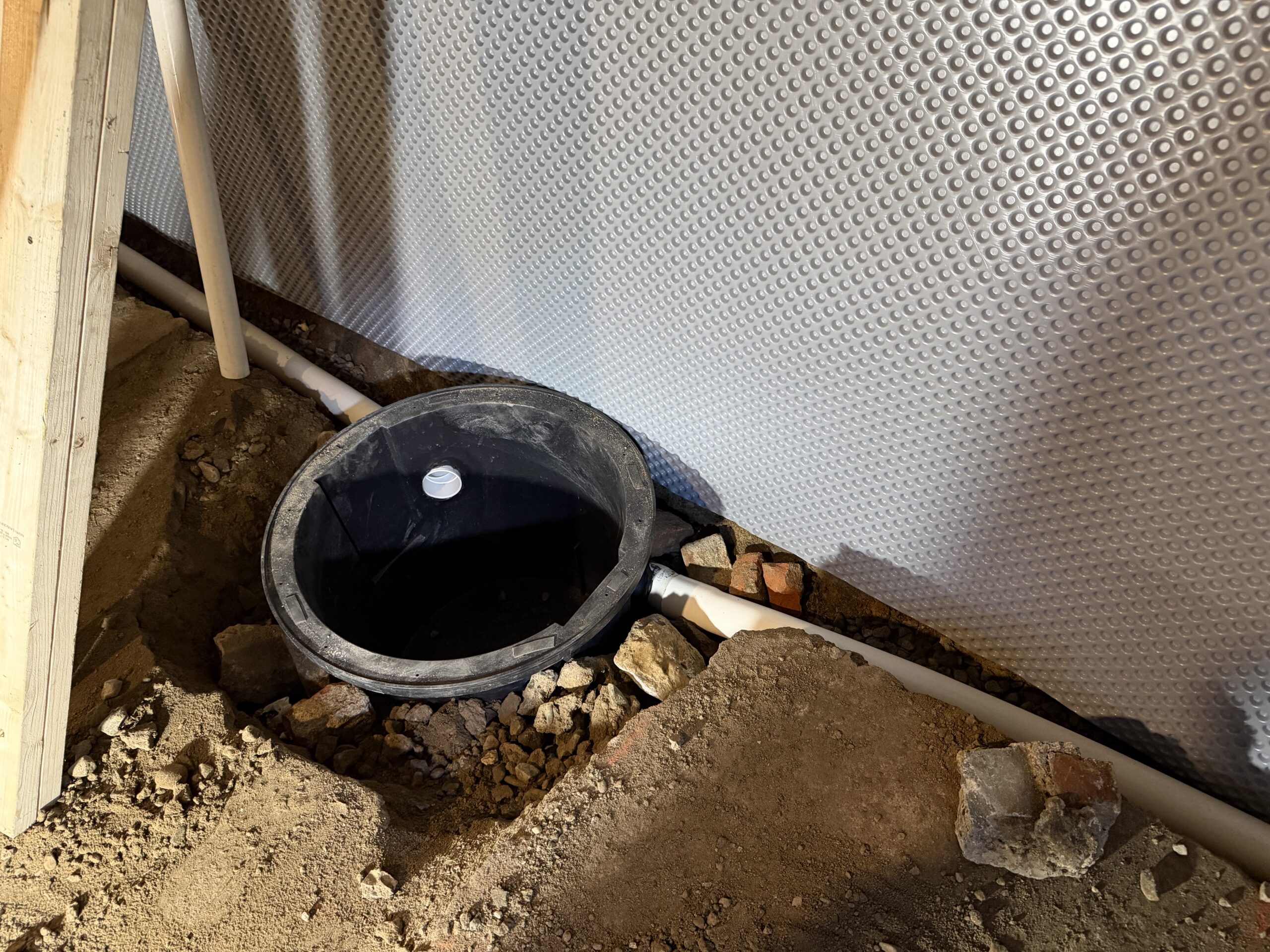 B‑Dry sump basin and interior drainage system installation in progress