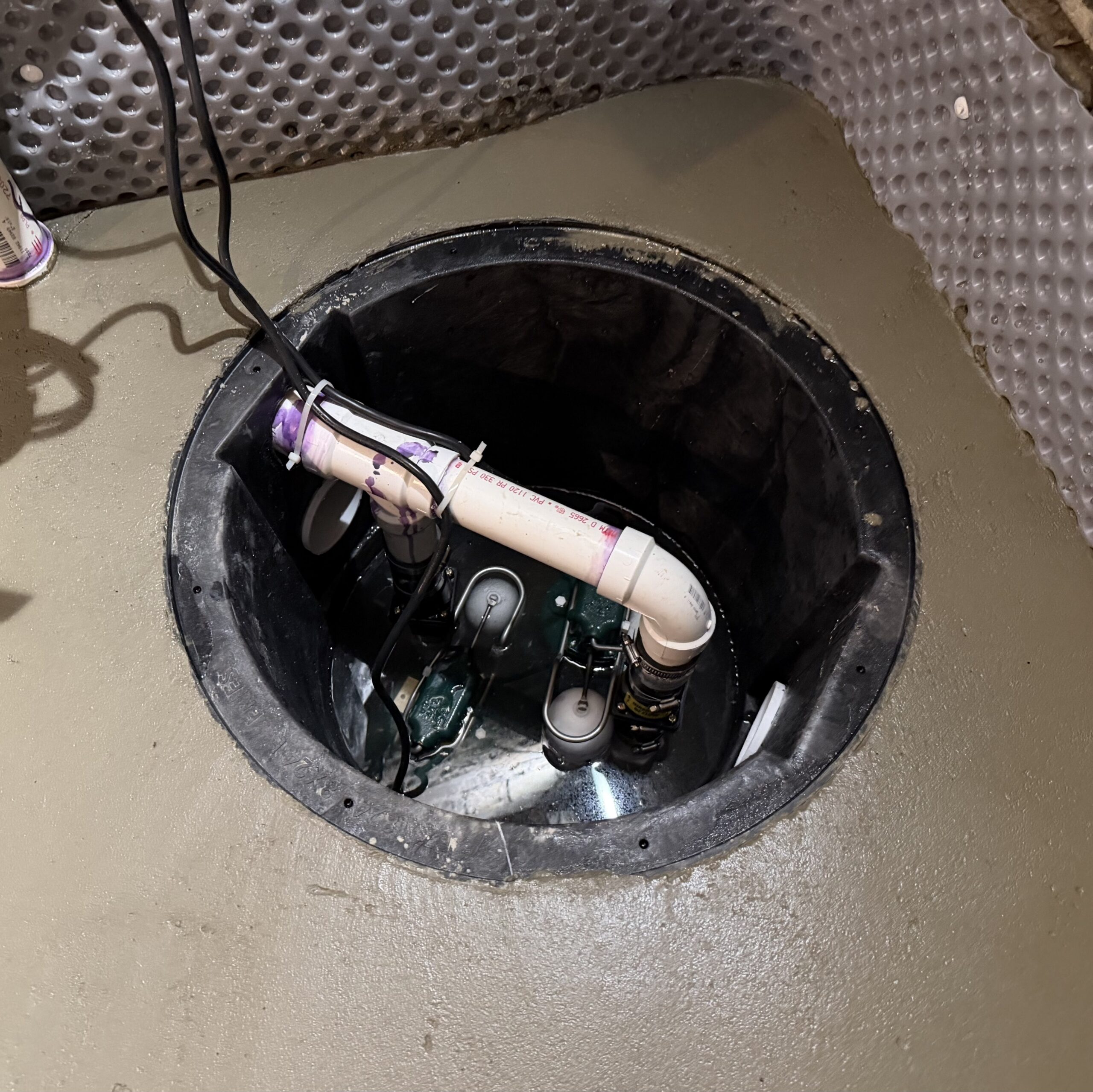 Two sump pumps installed inside a B‑Dry sump well